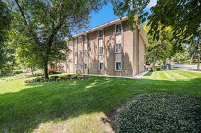 Grand Rapids apartment for rent - a brick building with trees and grass in front of it