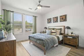San Antonio apartment for rent - A bedroom with a bed, nightstand, and a ceiling fan.