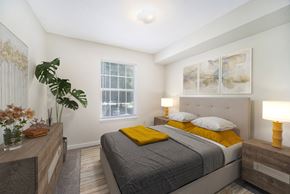 Greensboro apartment for rent - a bedroom with a bed and a dresser and a window