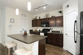 San Antonio apartment for rent - A kitchen with brown cabinets and a white refrigerator.
