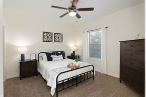 San Antonio apartment for rent - A bedroom with a bed, dresser, and ceiling fan.