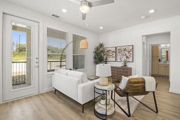 San Antonio apartment for rent - A living room with a white sofa and a chair with a brown cushion.