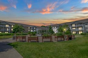 Madison apartment for rent - A sunset view of apartment buildings with a grassy area in the foreground.
