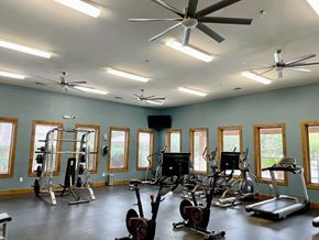 San Antonio apartment for rent - A spacious gym with a variety of equipment and a ceiling fan.