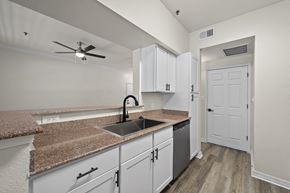 San Marcos apartment for rent - A kitchen with white cabinets and a granite countertop.