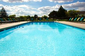 Grand Rapids apartment for rent - a large swimming pool with chairs around it