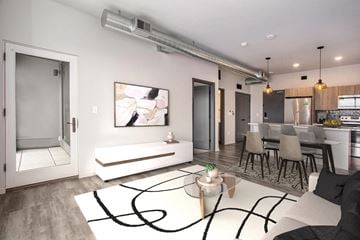 Grand Rapids apartment for rent - a living room with a white rug and a kitchen with a table and chairs