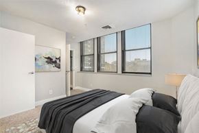 Grand Rapids apartment for rent - A bedroom with a large bed and a painting on the wall.