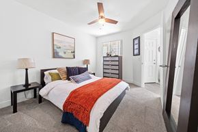 Flagstaff apartment for rent - A bedroom with a bed, a ceiling fan, and a painting on the wall.