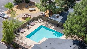 Flagstaff apartment for rent - A swimming pool surrounded by a patio and trees.