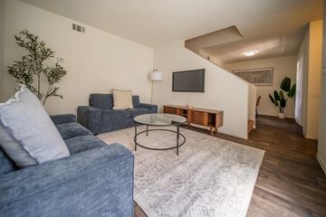 Flagstaff apartment for rent - A living room with a blue couch and a white rug.