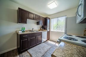 Flagstaff apartment for rent - One Bedroom A kitchen with brown cabinets and a white stove top oven.