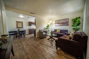 Flagstaff apartment for rent - A living room with a brown couch and a wooden floor.