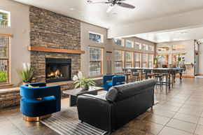 Flagstaff apartment for rent - A living room with a stone fireplace and blue chairs.