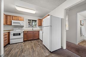 Flagstaff apartment for rent - A kitchen with wooden cabinets and a white refrigerator.