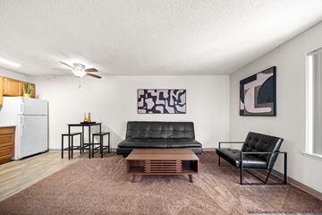 Flagstaff apartment for rent - A living room with a black leather couch and a wooden coffee table.