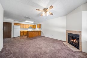 Cottonwood apartment for rent - A living room with a fireplace and a ceiling fan.