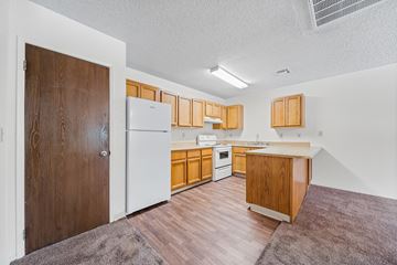 Cottonwood apartment for rent - A kitchen with wooden cabinets and a white fridge.