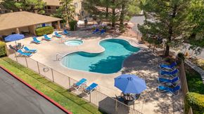 Cottonwood apartment for rent - A pool surrounded by chairs and umbrellas.