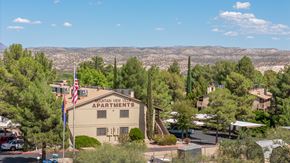 Cottonwood apartment for rent - A building with the sign "Mountain View Apartments" is surrounded by trees and has an American flag flying in front of it.