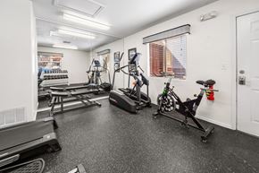 Cottonwood apartment for rent - A fitness center with a treadmill, stationary bike, and weights.
