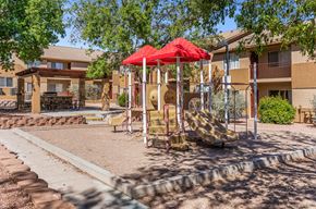 Cottonwood apartment for rent - A playground with a red umbrella and a slide.