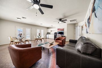 Tucson apartment for rent - A living room with a brown leather couch and a ceiling fan.