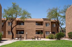Tucson apartment for rent - A building with a brown facade and a green lawn in front.