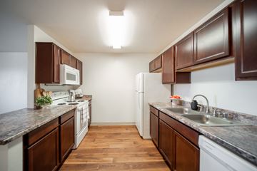Oro Valley apartment for rent - A kitchen with brown cabinets and a white refrigerator.