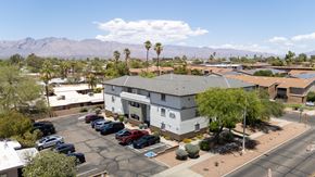 Tucson apartment for rent - A parking lot with cars and a building in the background.