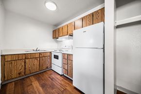 Tucson apartment for rent - A white refrigerator in a kitchen with wooden cabinets.