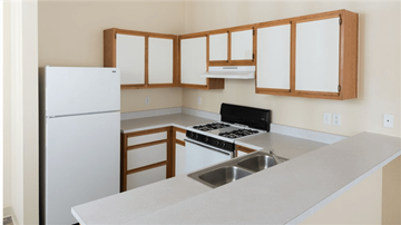 Cottonwood apartment for rent - a kitchen with white counters and white appliances and wooden cabinets