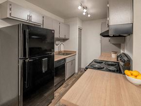 Tucson apartment for rent - a kitchen with a stove top oven next to a refrigerator