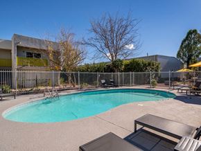 Tucson apartment for rent - a pool with a fence around it and a building in the background