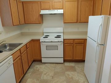 Waldorf apartment for rent - A kitchen with wooden cabinets and a white stove top oven.