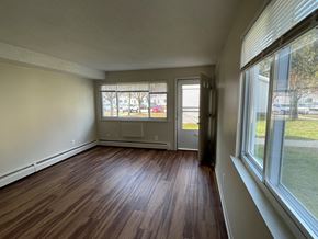 Moosup apartment for rent - an empty living room with hardwood floors and large windows