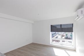 West Hartford apartment for rent - A room with a window showing a view of a street with cars and buildings.