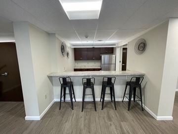 New Milford apartment for rent - a kitchen with a bar and three stools in front of a kitchen counter top
