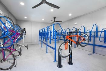 A room filled with bikes on racks and a ceiling fan