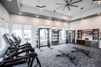 A gym with treadmills, weights, and exercise benches