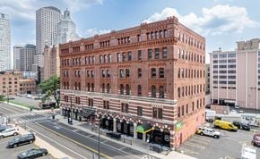 Hartford apartment for rent - A red brick building with a green awning sits on a street corner.