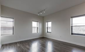 Hartford apartment for rent - A spacious room with wooden floors and three windows.