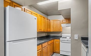 Washington apartment for rent - A kitchen with a white refrigerator and wooden cabinets.