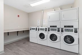 East Greenwich apartment for rent - A laundry room with three washing machines and a bench.