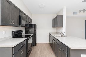 East Greenwich apartment for rent - A kitchen with black cabinets and white countertops.