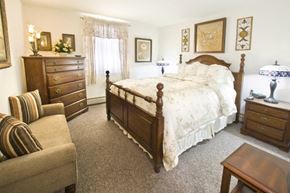 Troy apartment for rent - a bedroom with a bed and a chair and a dresser