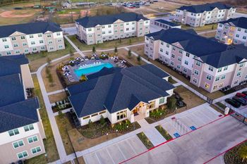 An aerial view of a large house with a swimming pool in the middle of it