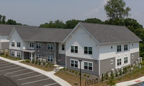 Mechanicville apartment for rent - A modern two-story building with a parking lot in front.