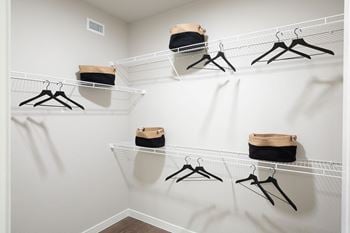 A spacious walk in closet in a bedroom plus den unit 