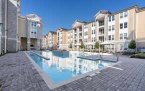 Katy apartment for rent - A large swimming pool surrounded by apartment buildings.